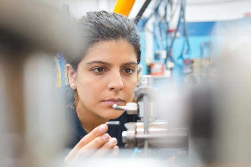 Female engineer examining machinery in industry
